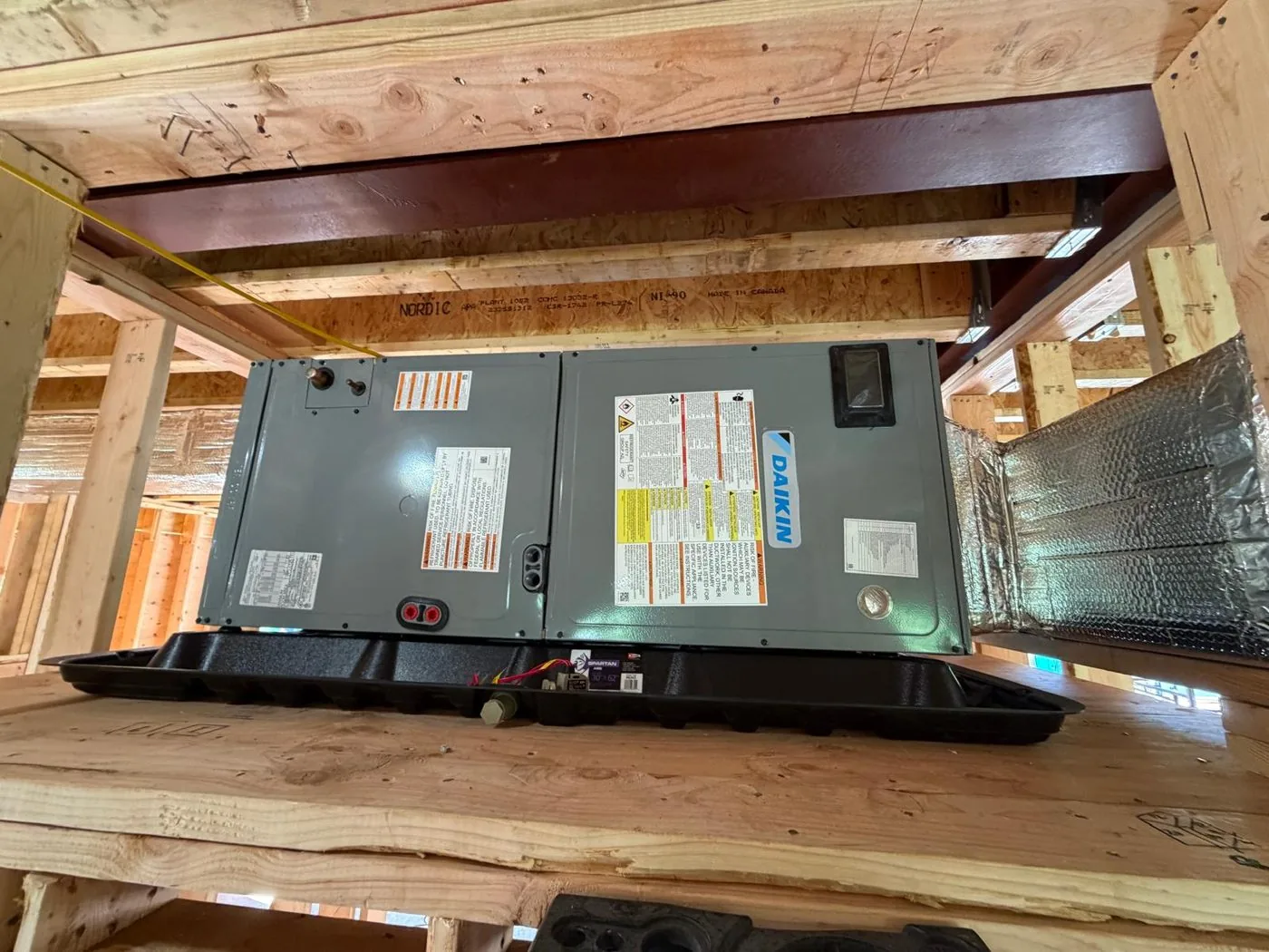 A horizontal air handler installed between the floor joists of a crawlspace