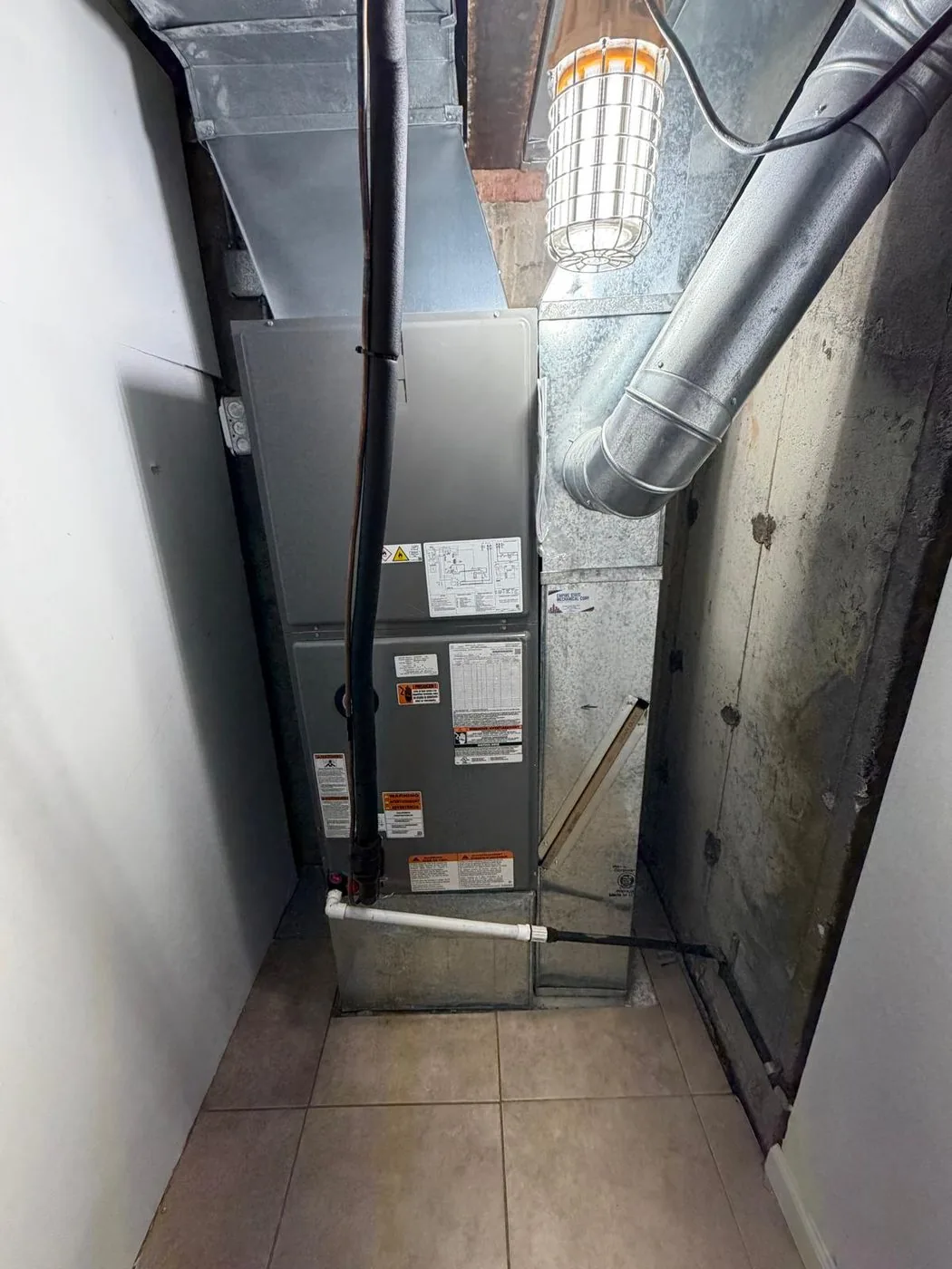 A replacement air handler and sheet metal plenum installed in a utility closet